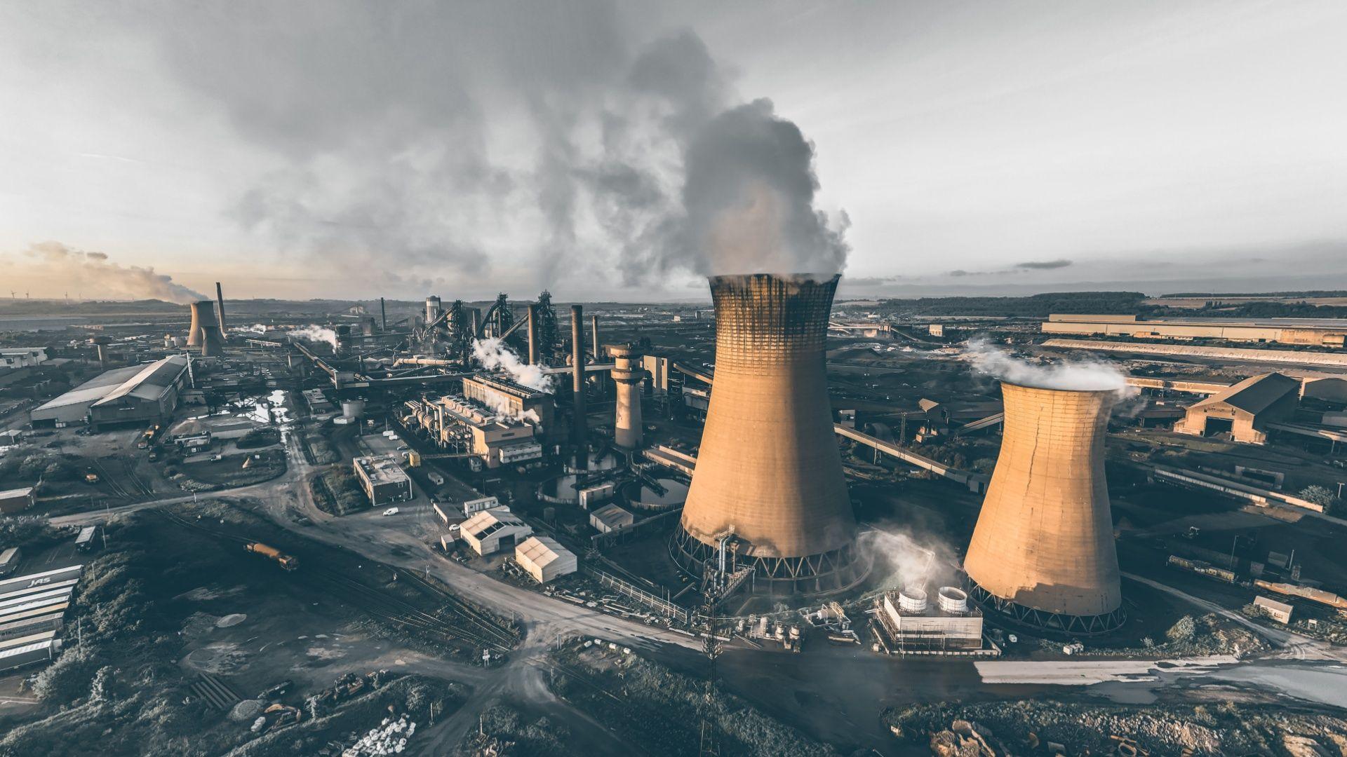 Aerial view of Scunthorpe steelworks showing a number of industrial buildings and steam rising from large chimneys
