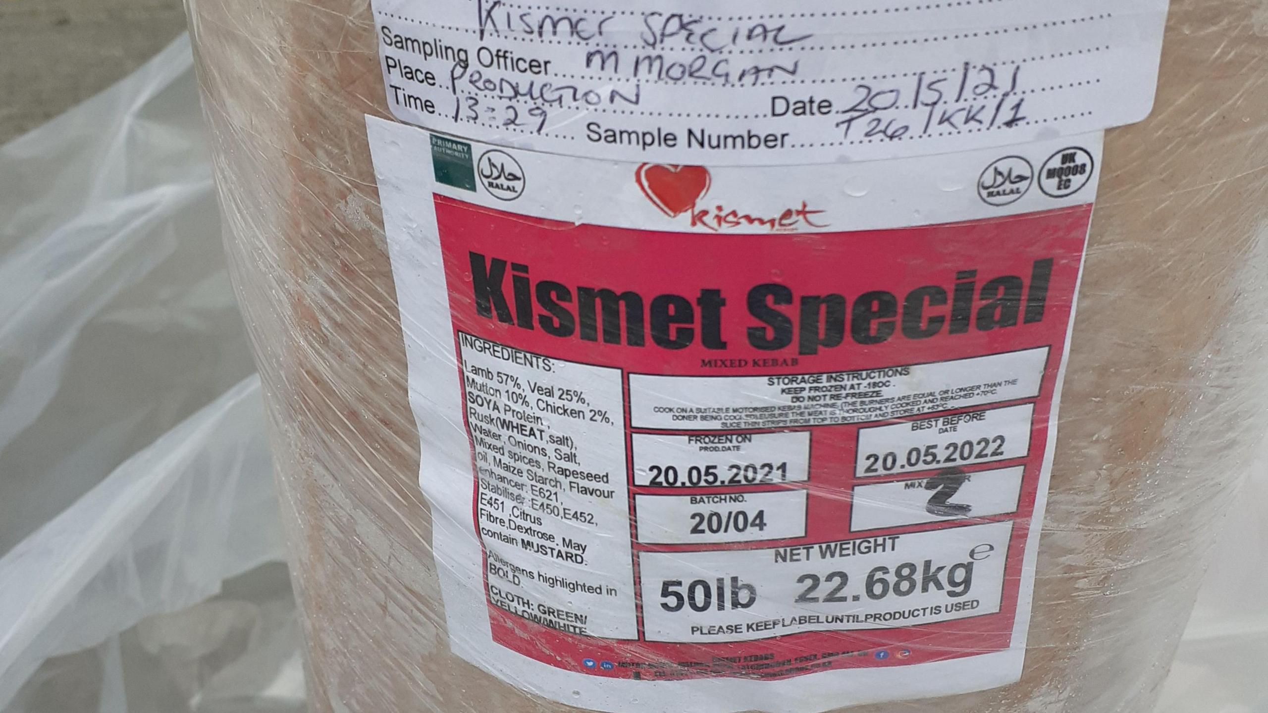 Pink kebab paste in the shape of a long donor covered in cling film with an ingredients label on it