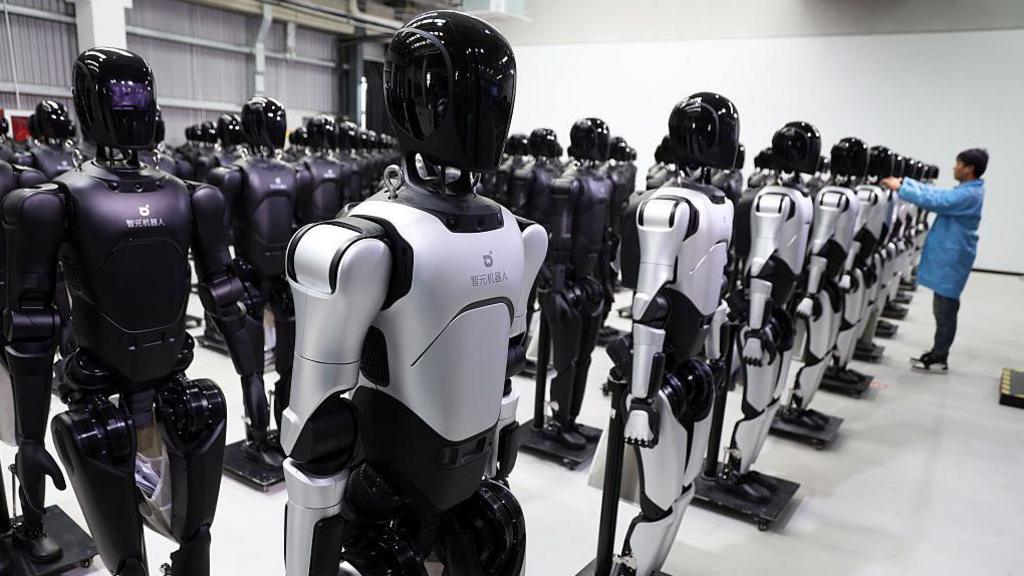 An engineer debugs robots at the factory of AgiBot, a leading robotics company