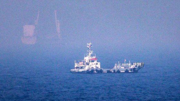 A ship is seen in blue water off the eastern coast of the United Arab Emirates.