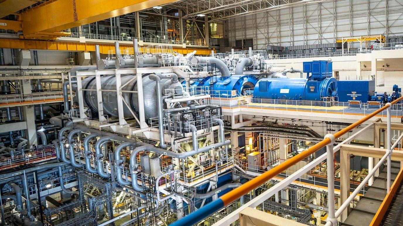 A photo of Sizewell B's turbine hall. It shows the interior of a very large room filled with machinery.