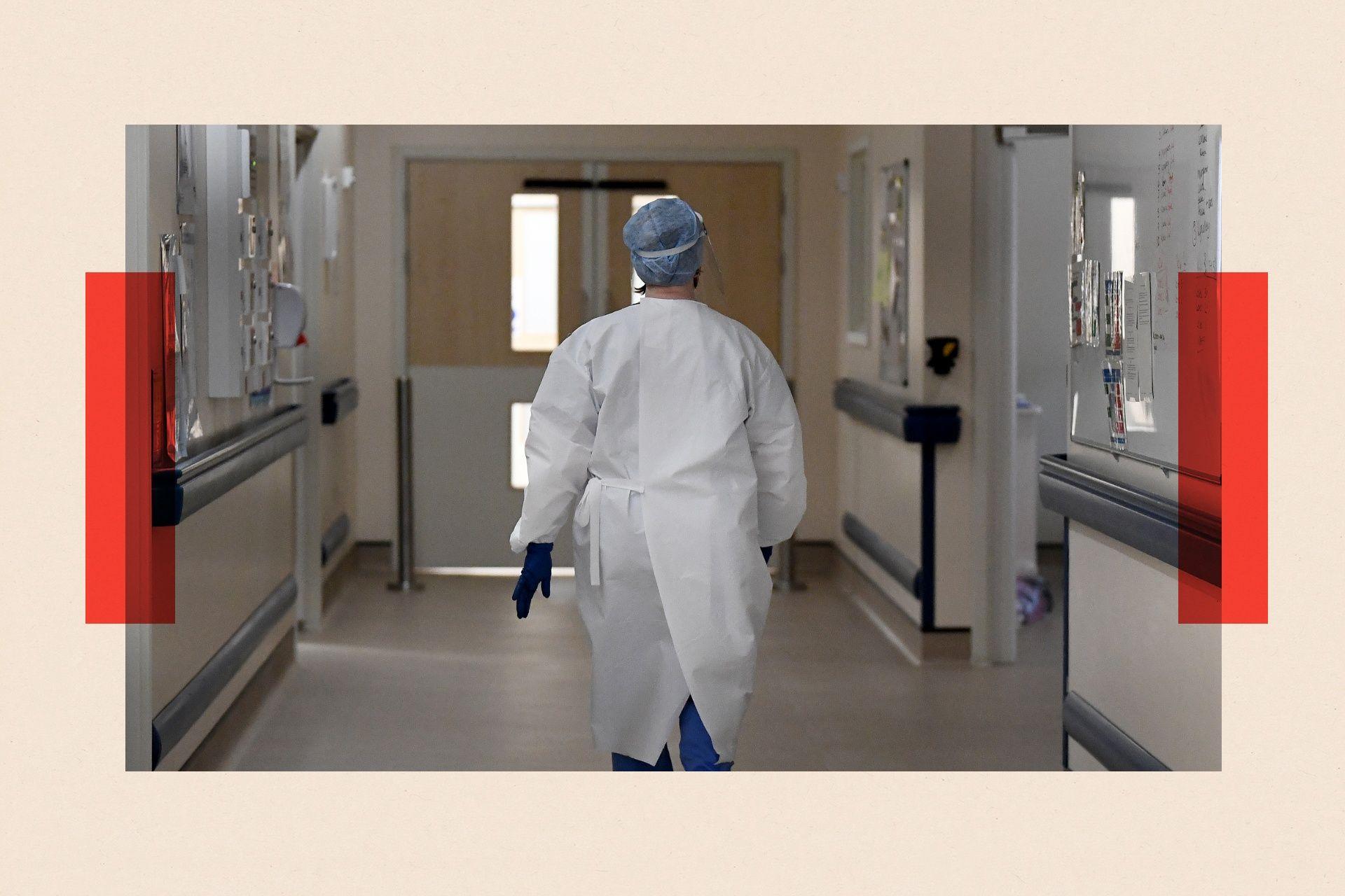 A member of staff walks in the ICU ward corridor at a hospital