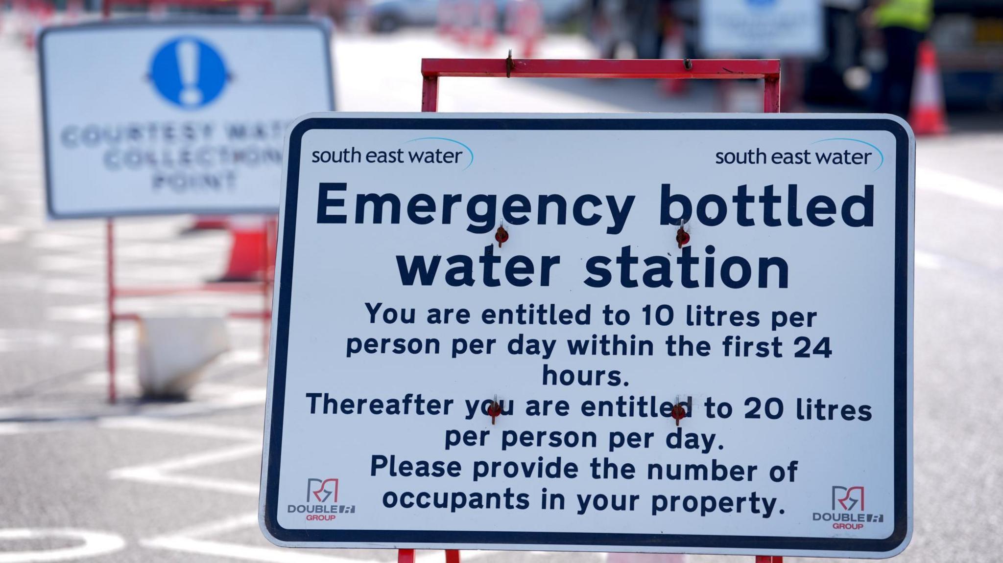 A sign that reads "emergency bottled water station" with further details of how much water visitors are entitled to collect. The sign features South East Water branding.