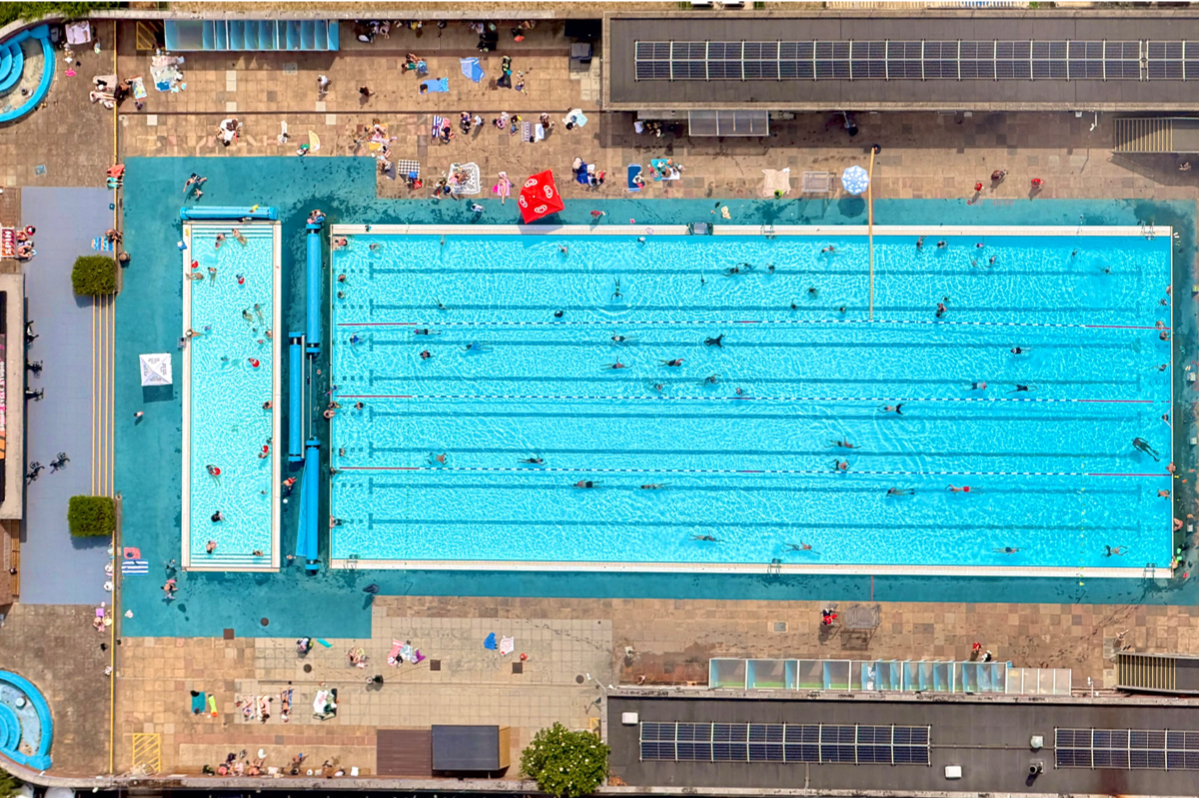 Goodyear blimp hovering over a luxurious pool, capturing a unique aerial view for a special event coverage